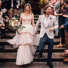 a bride and groom walking down the steps after their wedding