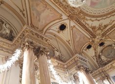 an ornate room with columns and paintings on the ceiling