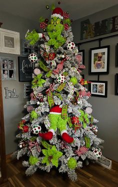 a christmas tree decorated with green and red ornaments in the shape of grin's head