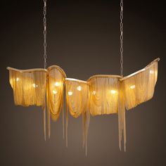 a chandelier hanging from chains with lights on it's sides and fringes