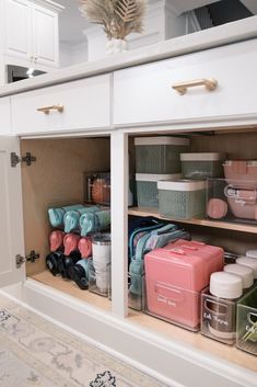 an open cabinet filled with lots of containers and baskets on top of it's sides