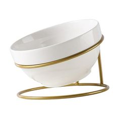 a white and gold bowl on a stand