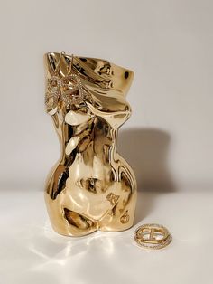 a gold vase sitting next to a diamond ring