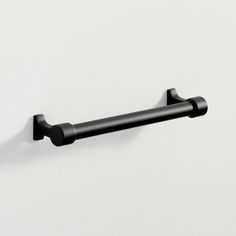 a black towel bar on a white wall