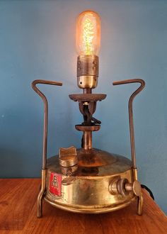 an old fashioned lamp sitting on top of a wooden table next to a blue wall