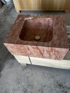 a bathroom sink made out of wood and marble with a wooden cabinet in the background