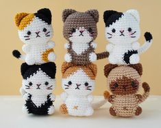 four crocheted cats are standing next to each other