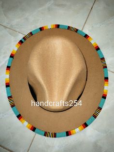 This is a beaded fedora hat. It's an adult size hat in the Lumbee tribe colors. Bohemian Green Fedora For Festivals, Beaded Brim Hat, Multicolor Bohemian Hat With Bead Caps, Handmade Southwestern Brimmed Felt Hat, Handmade Adjustable Green Hat Bands, Green Adjustable Handmade Hat Bands, Handmade Green Bohemian Fedora, Handmade Fedora For Beach Costume, Handmade Fedora For Festival