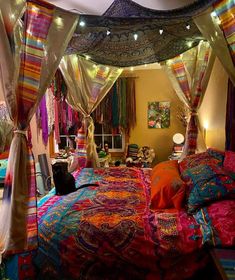 a bed with colorful bedspreads and lights hanging from it's sides in a bedroom