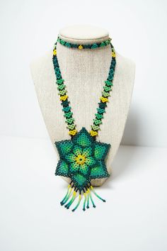 Native American Handmade Beaded Necklace with Beaded Floral Pendant in Yellow, Green, and Black, Handmade in Brooklyn, Vintage  Completely hand woven necklace by a Native American Artists in Jackson Heights, Queens, New York.  This lovely necklace is infinite and does not have a closure.  Measurements: Length: 13 inch Flower: 3X3 inches Fringe length: 1.5 inches Please be sure to check out my shop policy and jewelry care instructions before you place an order! Thank you so much for visiting my shop and supporting local artists. Meanwhile, Check out my social media accounts for fun posts and updates: Instagram: https://www.instagram.com/nakkalinaani/ Facebook: https://www.facebook.com/nakkalinaaniofficial/ Pinterest: https://www.pinterest.com/nakkalinaani/ Artisan Green Handwoven Beaded Necklace, Bohemian Green Beaded Necklaces With Bead Caps, Hand-strung Green Beaded Necklaces For Festivals, Hand-strung Green Beaded Necklace For Festival, Green Hand-strung Beaded Necklaces For Festival, Green Hand-strung Beaded Necklace For Festival, Green Handwoven Beaded Necklace For Gifting, Green Handwoven Beaded Necklace For Gift, Green Handwoven Necklaces With Round Beads