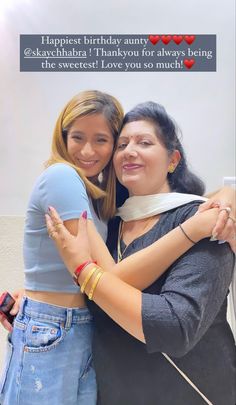 two women hugging each other in front of a birthday card