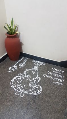 a potted plant sitting next to a chalk drawing on the floor