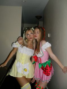 two women dressed in costumes standing next to each other