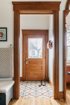 an entryway with a bench and wooden door