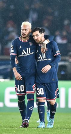 two soccer players standing next to each other on a field