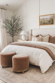 a bedroom with a large bed and two stools