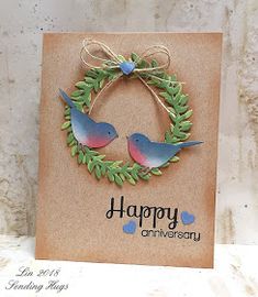 a happy anniversary card with two birds in a wreath on the front and back of it