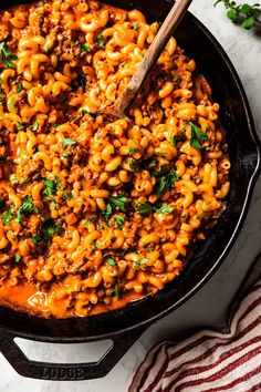 a skillet filled with macaroni and cheese on top of a white counter