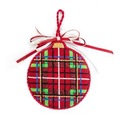 a red ornament with a plaid pattern hanging from it's side on a white background