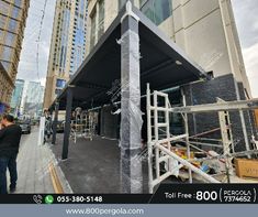 a man standing next to a tall building under construction