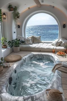 an indoor hot tub in the middle of a room with a large window overlooking the ocean