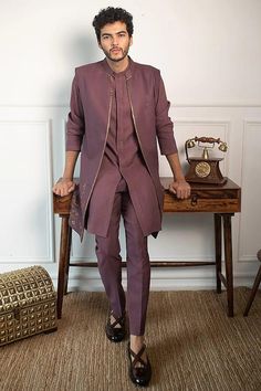 a man standing in front of a wooden table