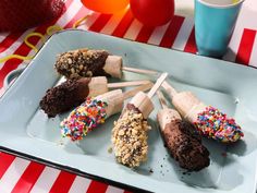 there are many different types of ice creams on the plate with strawberries and balloons in the background