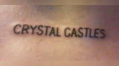 the word crystal castles written in cursive ink on someone's lower back