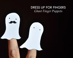 two ghost finger puppets are being held in front of the camera