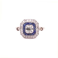 Art Deco style Ascher cut sapphire and diamond target cluster ring mounted in platinum. The central asher cut diamond weighing 0.50cts H colour VS clarity surrounded by a calibre cut sapphire border and an outer round diamond border and graduated diamond set shoulders and an intricate pierced lower gallery.  Total diamond weight approximately 0.85cts. Total sapphire weight approximately 0.35cts. Please note this ring can be re sized prior to shipping. Gia-certified Cluster Sapphire Ring With Diamond, Gia Certified Cluster Sapphire Ring With Diamond, Asscher Cut Diamond Lab-created Sapphire Ring, Vvs Clarity Asscher Cut Sapphire Ring In Platinum, Asscher Cut Sapphire Ring In Platinum With Vvs Clarity, Lab-created Asscher Cut Sapphire Ring With Diamond Cut, Asscher Cut Lab-created Sapphire Ring With Diamond Cut, Brilliant Cut Octagon Sapphire Ring In Platinum, Octagon Brilliant Cut Sapphire Ring With Diamond