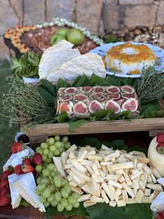 an assortment of cheeses, fruits and vegetables on display