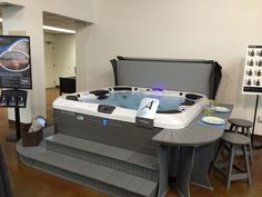 a large hot tub sitting in the middle of a room next to two stools