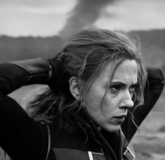 black and white photograph of a woman with her hair blowing in the wind, wearing a leather jacket