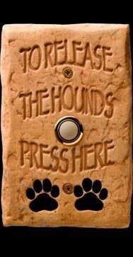 a stone sign that says to release the hounds press here with paw prints on it