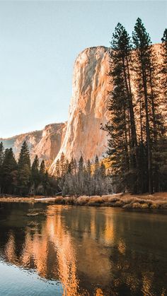 an image of a mountain lake with trees around it and the sun reflecting in the water