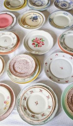 a table topped with lots of different colored plates