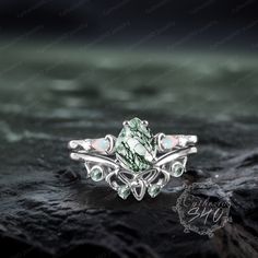 a ring with green and white stones on it