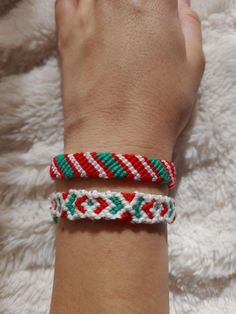 two bracelets on someone's wrist that are both red and green