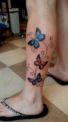 a woman's foot with butterflies on it and the bottom part of her leg