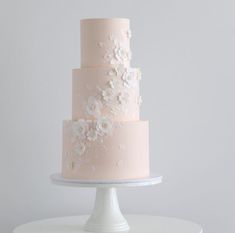 a three tiered cake with white flowers on it