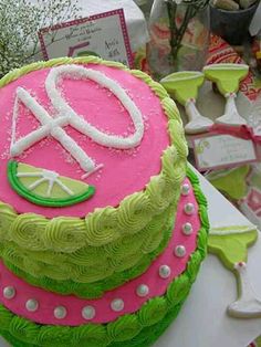 a pink and green cake sitting on top of a table