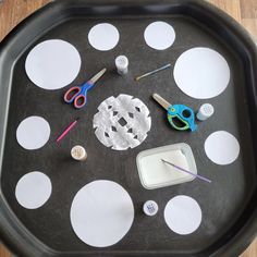 a black tray with white polka dots and scissors