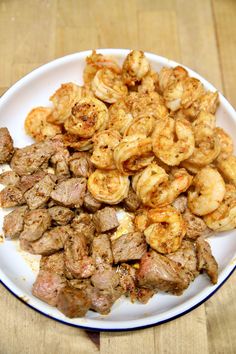 a white plate topped with meat and shrimp