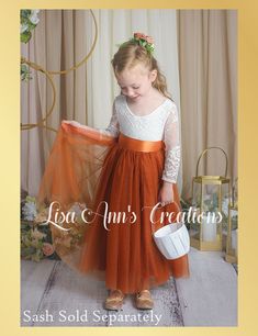 Burnt Orange Flower Girl Dress in Long Sleeves This luxurious tulle flower girl dress in a whimsical boho style adds a refined touch to any wedding. This dress is so soft and light your child will love wearing it. Available in so many colors it will be hard to choose just one. Dress Features A soft white bodice, made of stretchy lace with a "V" shaped on the back, edged with delicate lace A cotton liner under 2 layers of soft tulle that won’t itch your princess. Dress length of mid-calf to floor