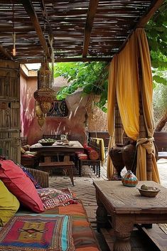 an outdoor living area with couches, tables and wicker structures on the ceiling