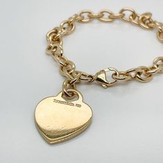 This is part of Chairish’s Fine Jewelry assortment.  A very fine Tiffany Co. bracelet.  In 18k gold.  With slightly oval links and a heart-shaped pendant charm.  The charm is not engraved.  Simply wonderful, classic Tiffany design!  Date: 20th Century  Overall Condition: It is in overall good, as-pictured, used estate condition with some very fine light surface scratches and other signs of expected light wear consistent with age.  Fineness: Marked 750 for 18k gold fineness.  Marks: Tiffany Co. / Classic Engraved Oval Link Chain Bracelet, Luxury Gold-tone Tarnish Resistant Charm Bracelet, Classic Heart Charm Bracelet In White Gold, Classic White Gold Charm Bracelet With Heart Charm, Classic White Gold Charm Bracelet With Heart, Luxury Engraved Oval Link Chain Bracelet, Classic Gold Heart Bracelet, Classic Gold Bracelets For Valentine's Day, White Gold Classic Heart Charm Bracelet