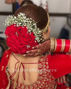 the back of a woman's head with flowers in her hair and red dress