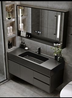 a bathroom with a sink, mirror and shelves on the wall next to the toilet