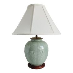 a green lamp with a white shade on it