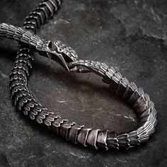 This dramatic snake necklace is a real showstopper. Wrap this black stainless steel monster around your neck and people are sure to take notice! With it's chunky stainless steel construction, you'll know you're wearing something very special. Length approx 24" (60cm) Black Metal Snake-shaped Jewelry, Snake Shape Box Chain Metal Necklace, Unique Black Snake-shaped Jewelry, Unique Metal Snake-shaped Necklace, Unique Black Stainless Steel Jewelry, Black Metal Snake Chain Jewelry, Black Metal Snake Chain Necklace, Gunmetal Stainless Steel Necklace With Oxidized Finish, Gunmetal Oxidized Stainless Steel Necklace